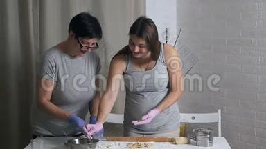 一个女人和她怀孕的女儿正在家里一起准备一顿美味的午餐。 他们碾碎，把面粉从